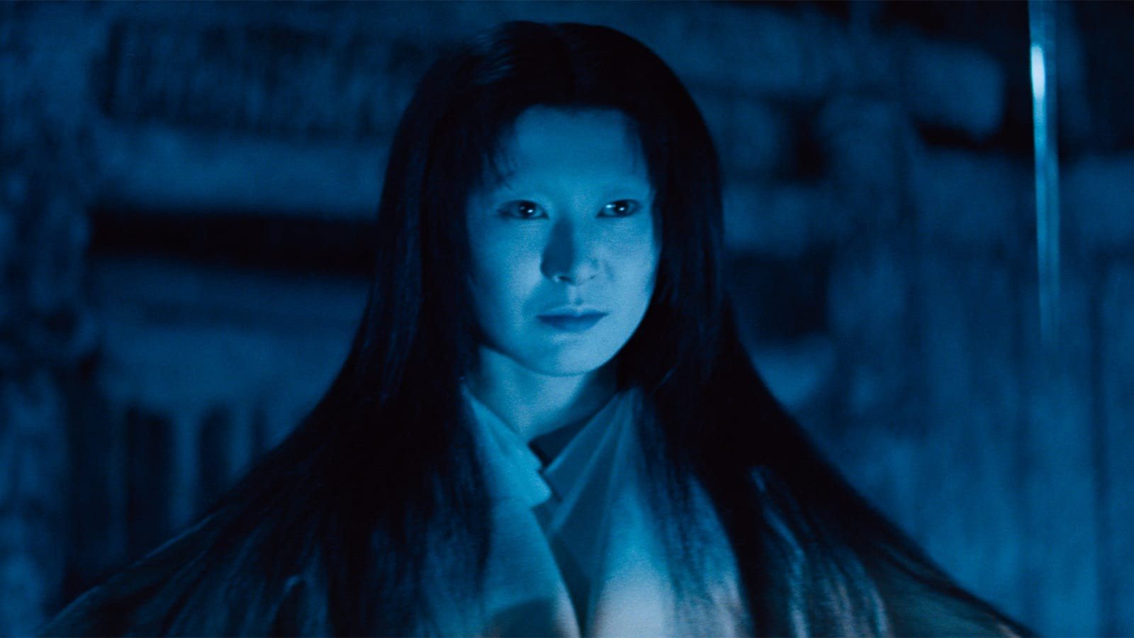 The woman of the snow, her face lit pale blue in the dark, long black hair loose around it