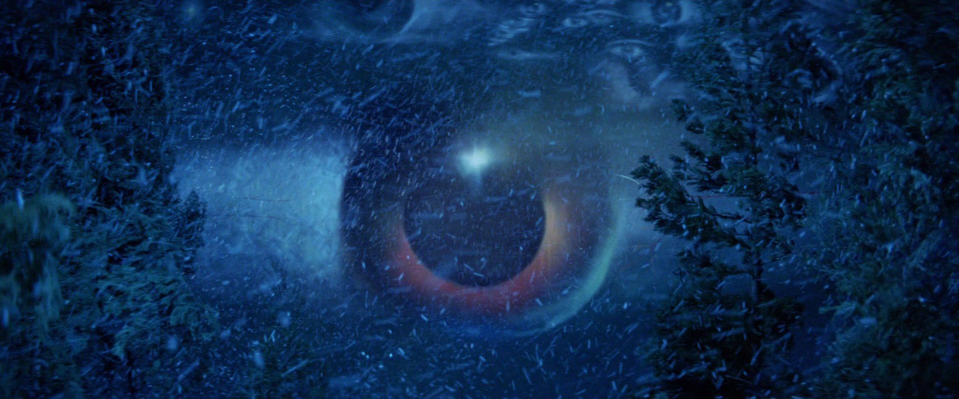 Inside a snow-blue forest, a huge eye painted across the night sky stares out between the trees
