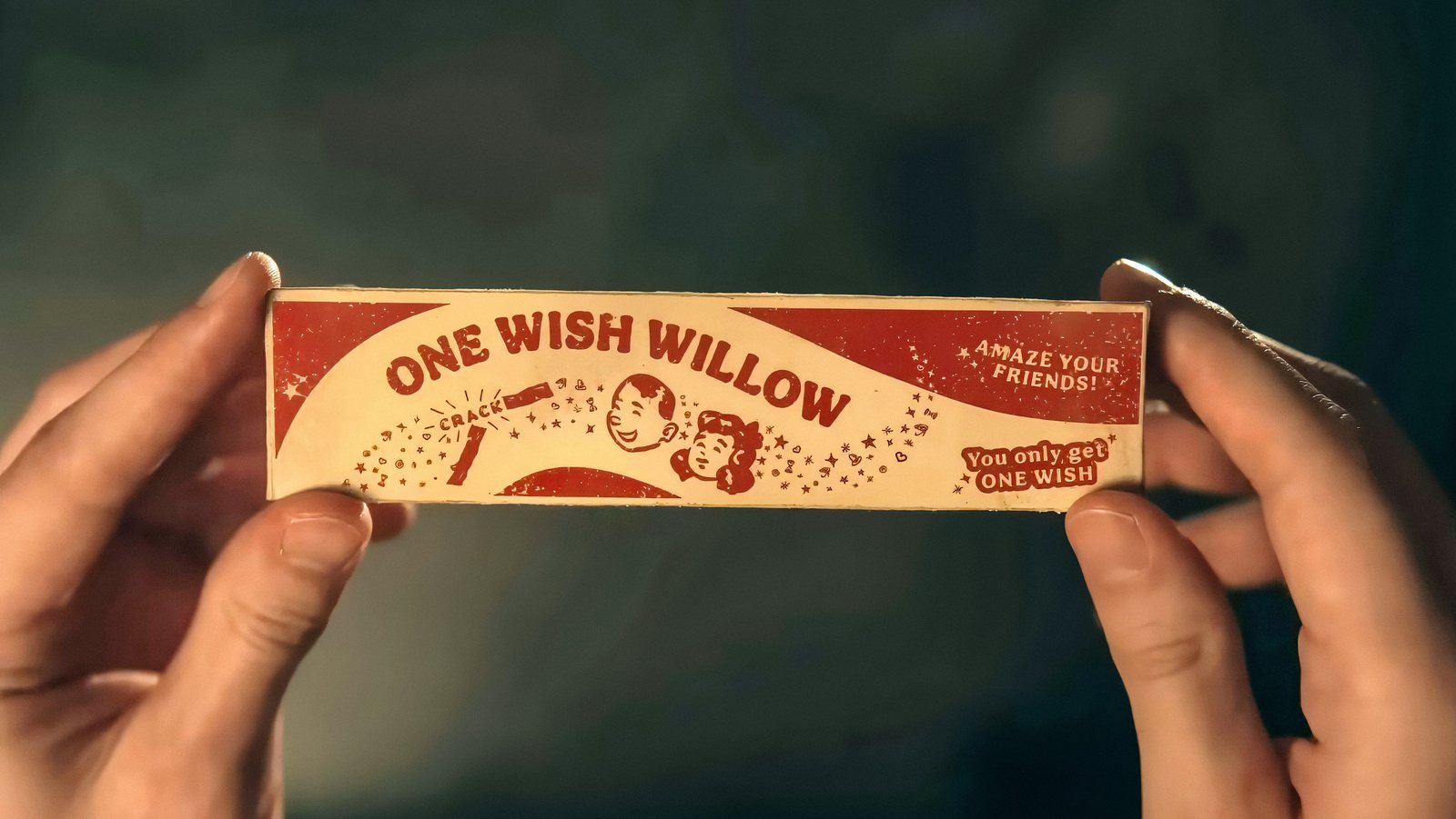 A close-up of two hands holding a small paper novelty stick printed “One Wish Willow,” with “Amaze your friends!” and “You only get one wish” in small letters