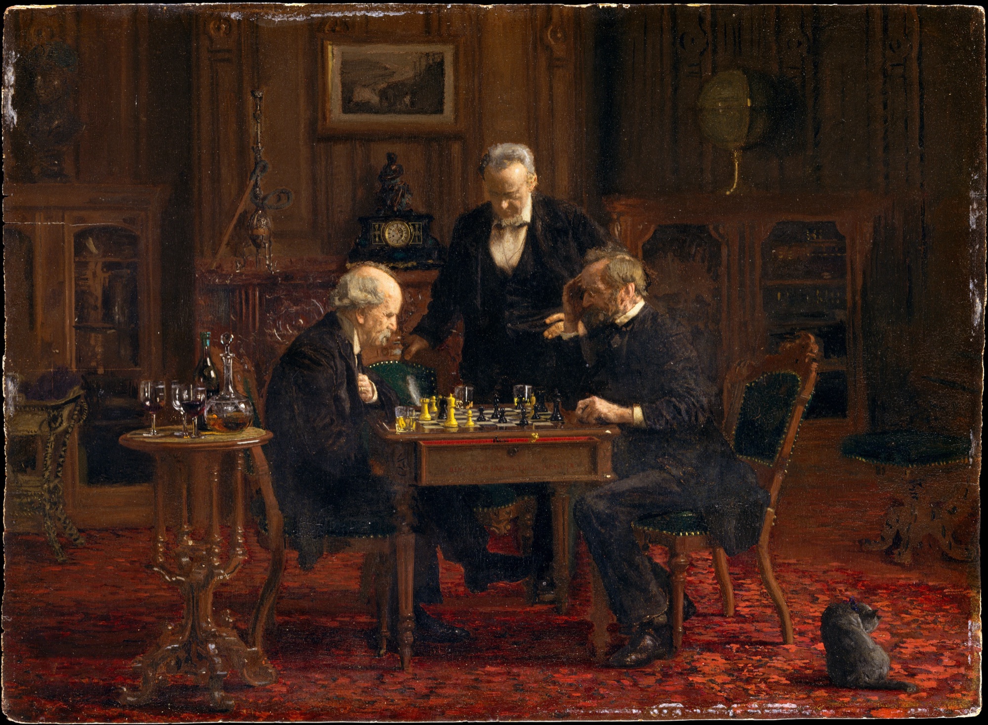 Two elderly men play chess at a small table in a dim, red-carpeted parlor while a third man stands behind them watching the board; a cat sits on the floor